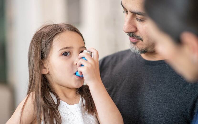 Kind met inhalator en zorgprofessional