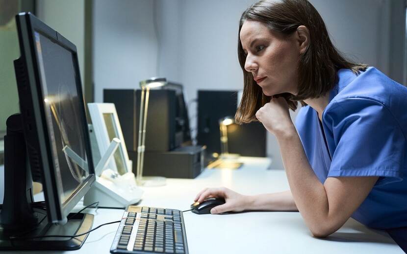 Zorgprofessional kijkend naar computerscherm