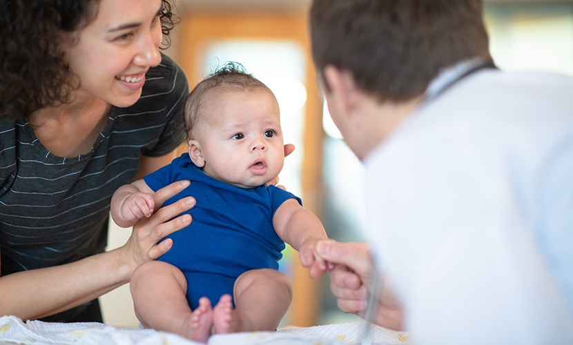 Zorgprofessional praat met moeder en baby