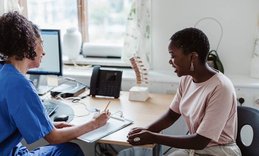 Zorgprofessional in gesprek met patiënt in de praktijk